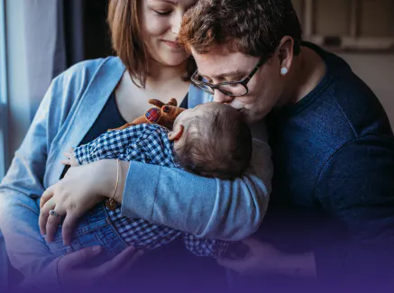 Family kissing an infant