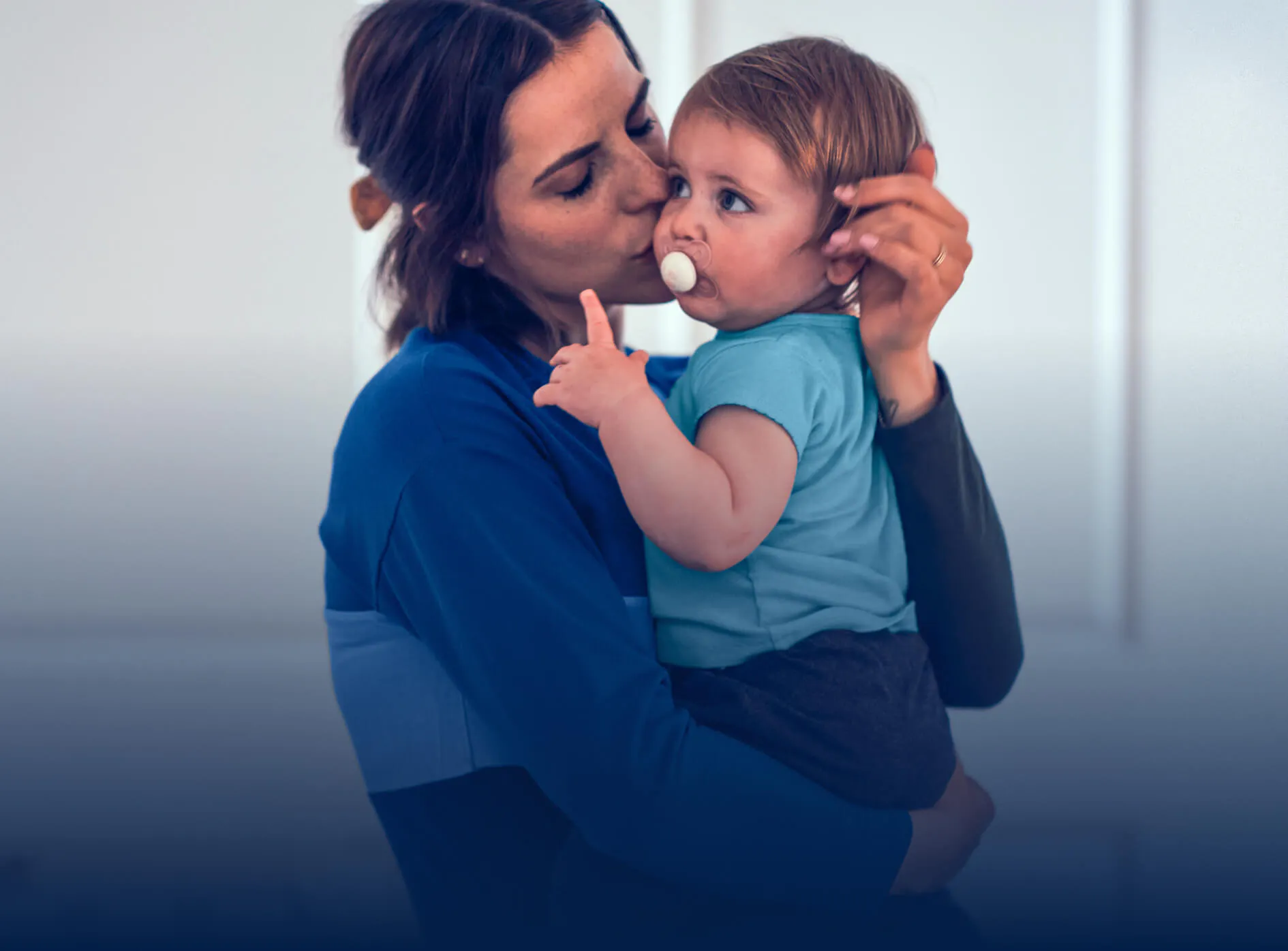 Mother holding and kissing a baby