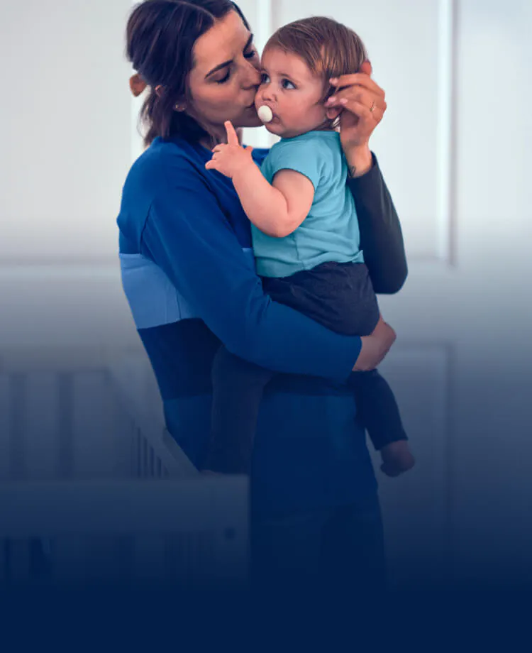 Mother holding and kissing a baby