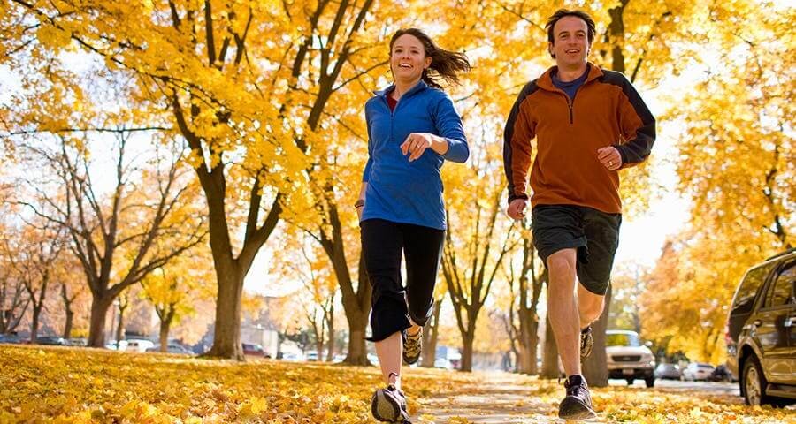 Young couple doing jogging in the park, smiling