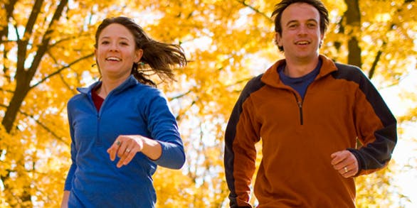 Young couple doing jogging in the park, smiling