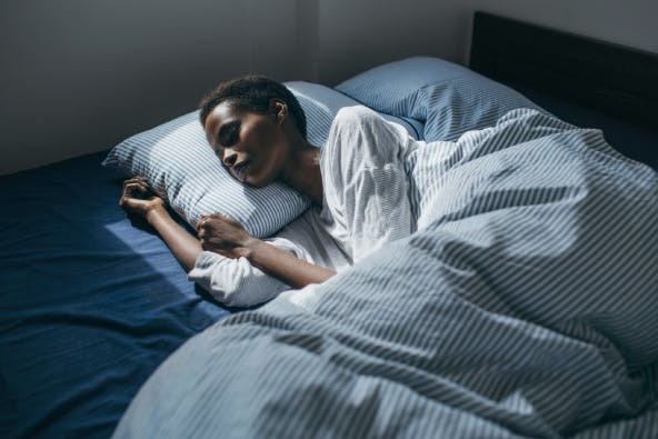 Person comfortably sleeping in bed