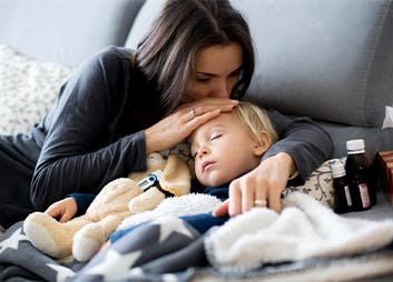 Mother kisses sick child’s forehead