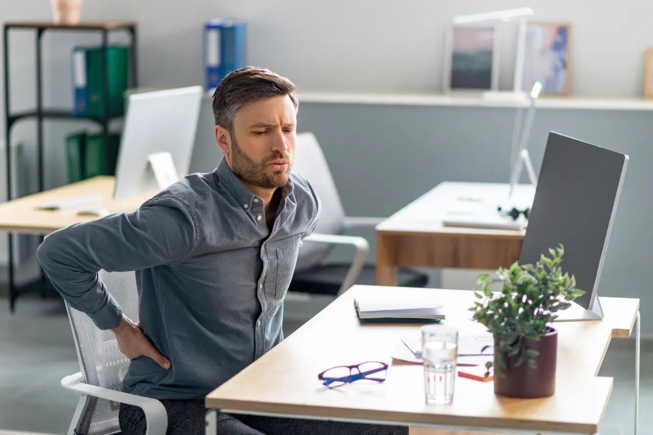 Man sitting at desk having middle back pain