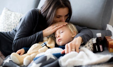 Madre besa la frente de su hijo enfermo