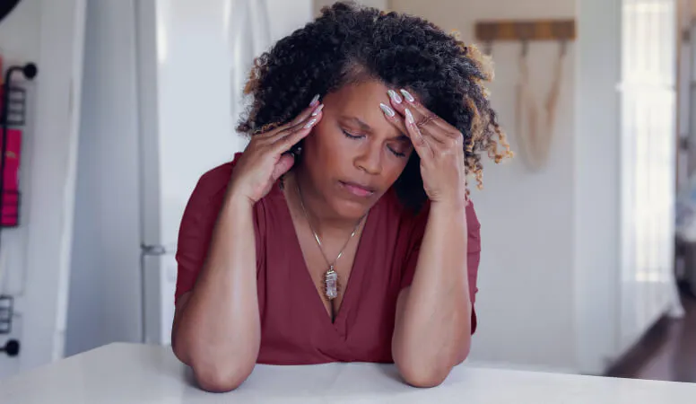 Femme se tenant la tête, en proie à une douleur