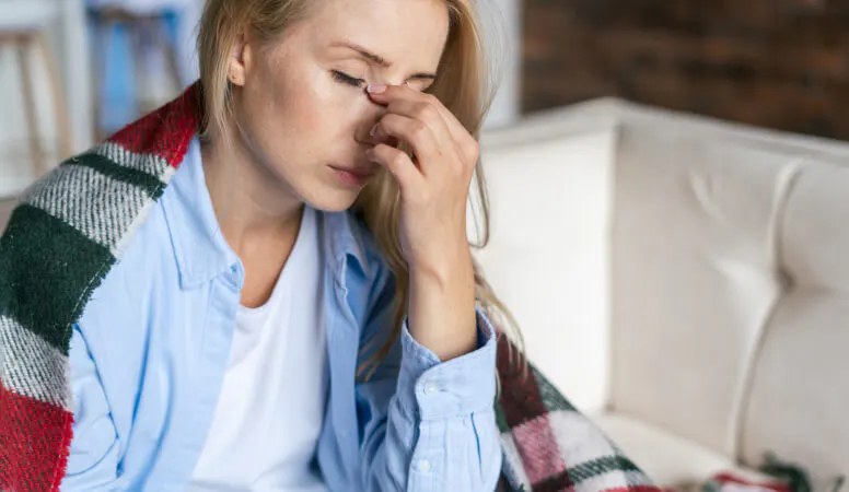 Personne se tenant la tête, en proie à une douleur