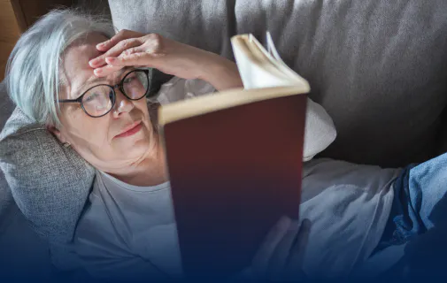 Femme lisant un livre sur son canapé