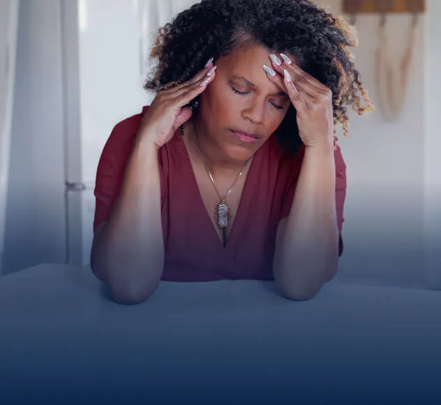 Femme se tenant la tête, en proie à une douleur