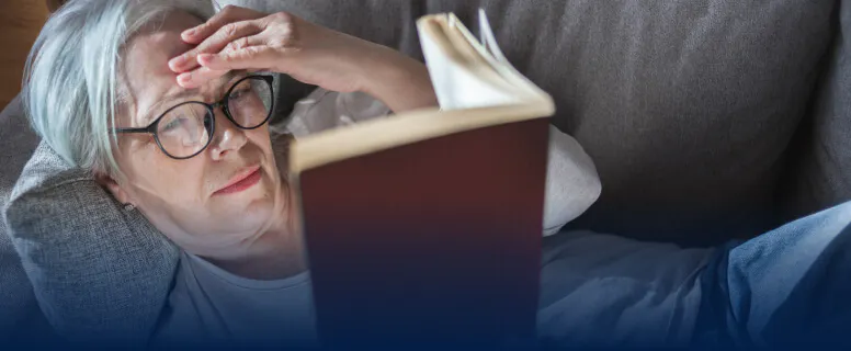 Femme lisant un livre sur son canapé