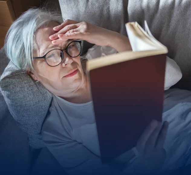 Femme lisant un livre sur son canapé