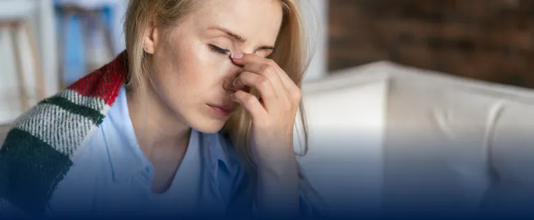 Personne se tenant la tête, en proie à une douleur