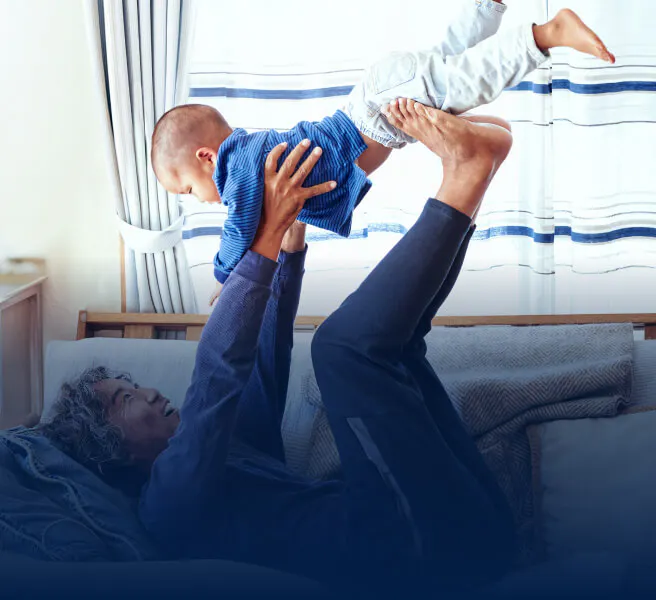 Personne couchée sur le dos, soulevant un bébé dans les airs