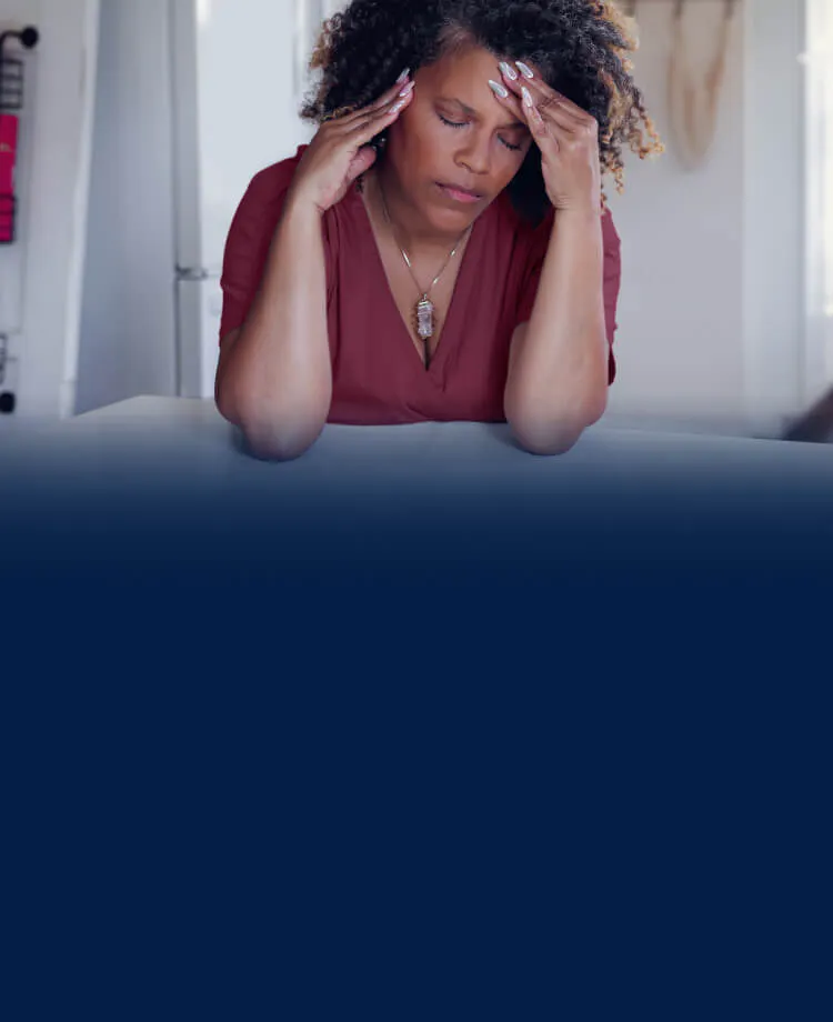 Femme se tenant la tête, en proie à une douleur