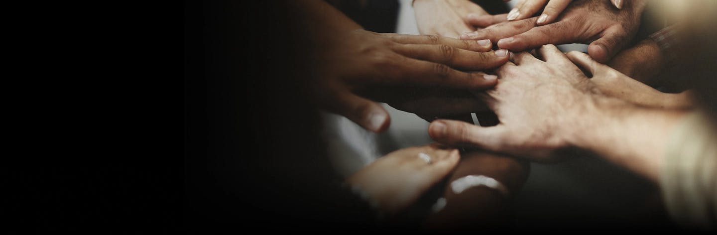 Photo of diverse group of hands coming together in a circle