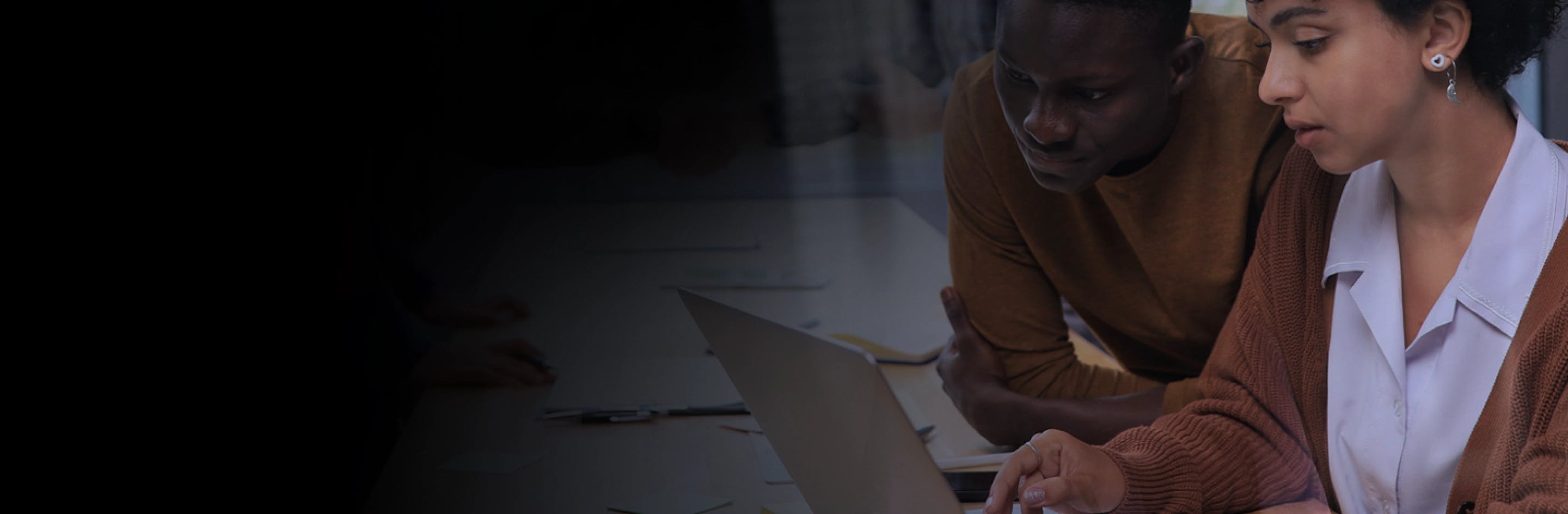 Photo of two individuals collaborating in an office setting