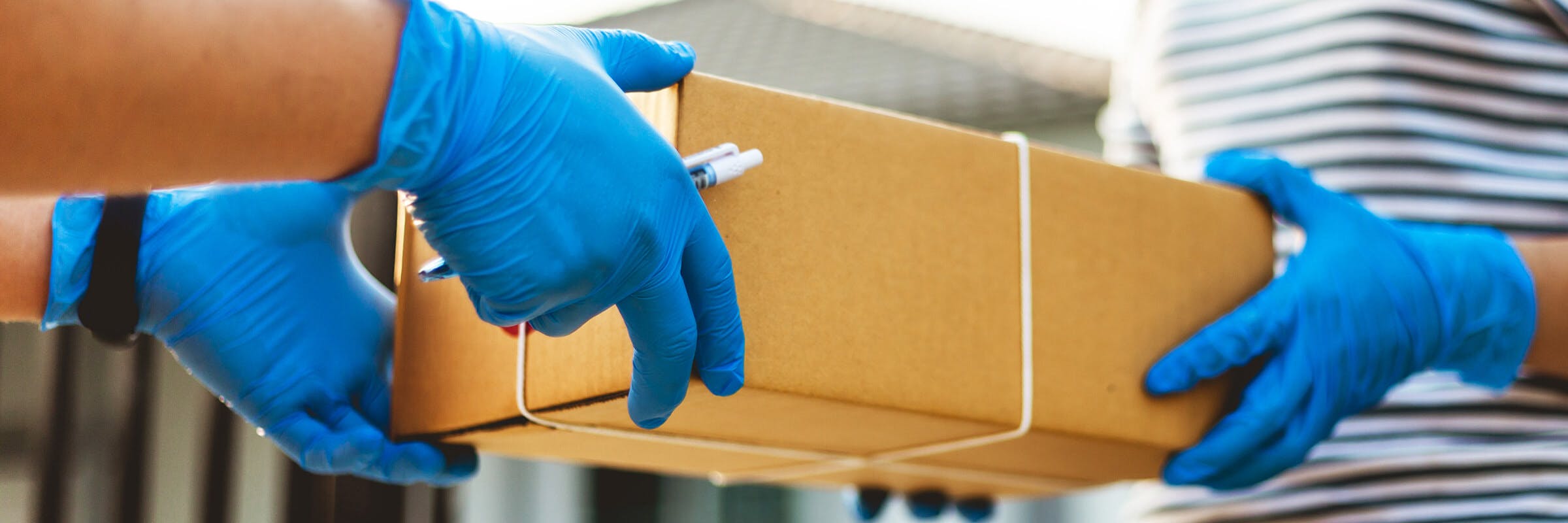 people with gloves handle package
