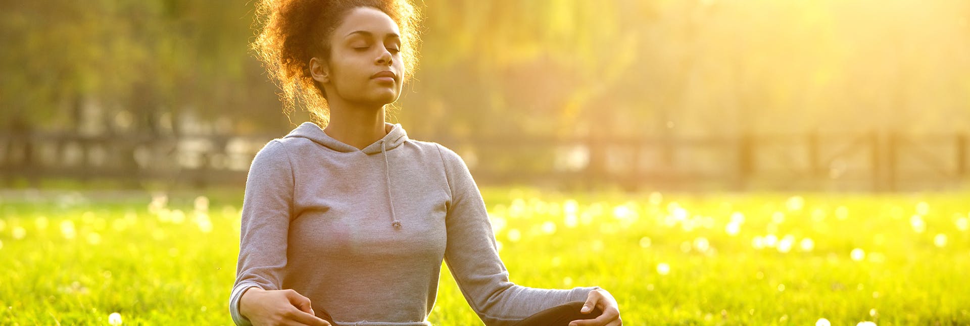 285334655 Young woman meditating in a field