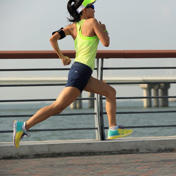 Young woman running by the water