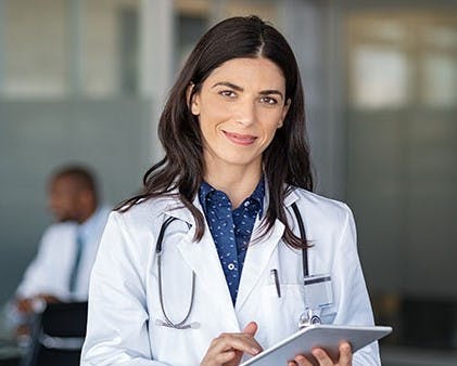 Woman in protective gear checking a clipboard in a lab