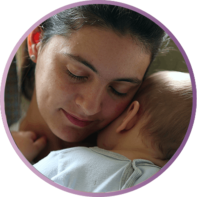 Smiling mom holds a sandwich and her baby