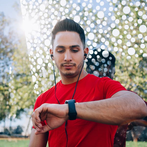 Man with headphones in checking his watch