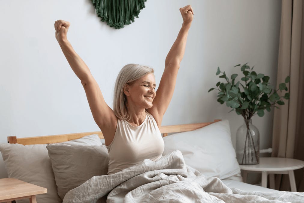 Frau im Bett, die sich erholt aufwacht und sich streckt. Frau im Bett, die sich erholt aufwacht und sich streckt.