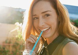 Woman smiling while drinking a juice