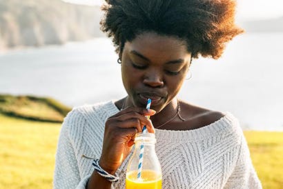 Young woman drinking orange juice.