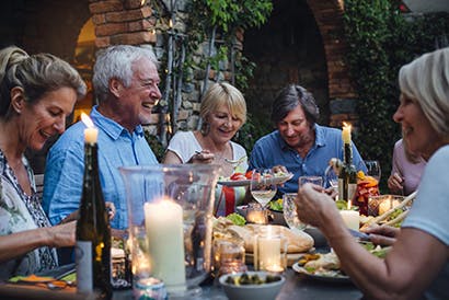 A group of elderly people sitting at a table eating together.