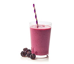 Berry Berry Bad Smoothie with purple striped straw in clear glass with blackberries