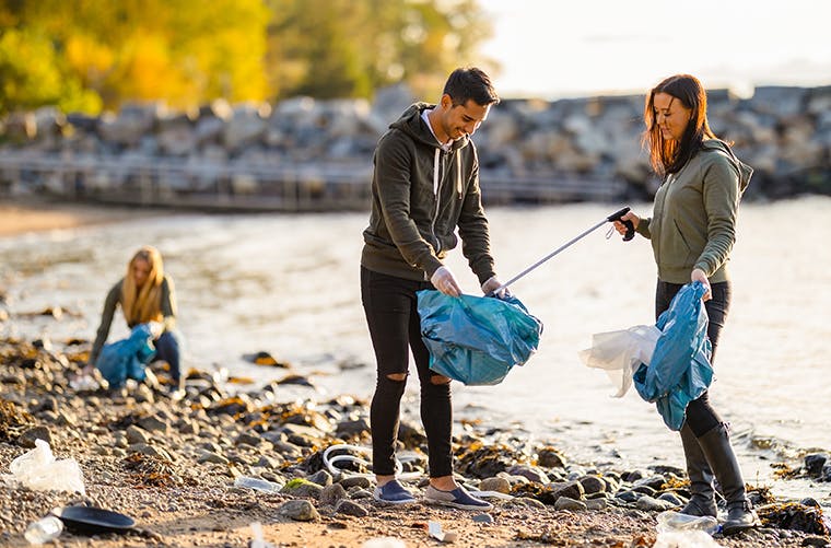 Man and woman picking up garbage on beach