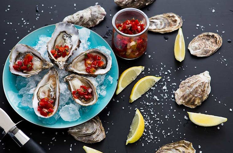 Plate of raw shucked oysters on ice. Oysters are a good source of zinc.