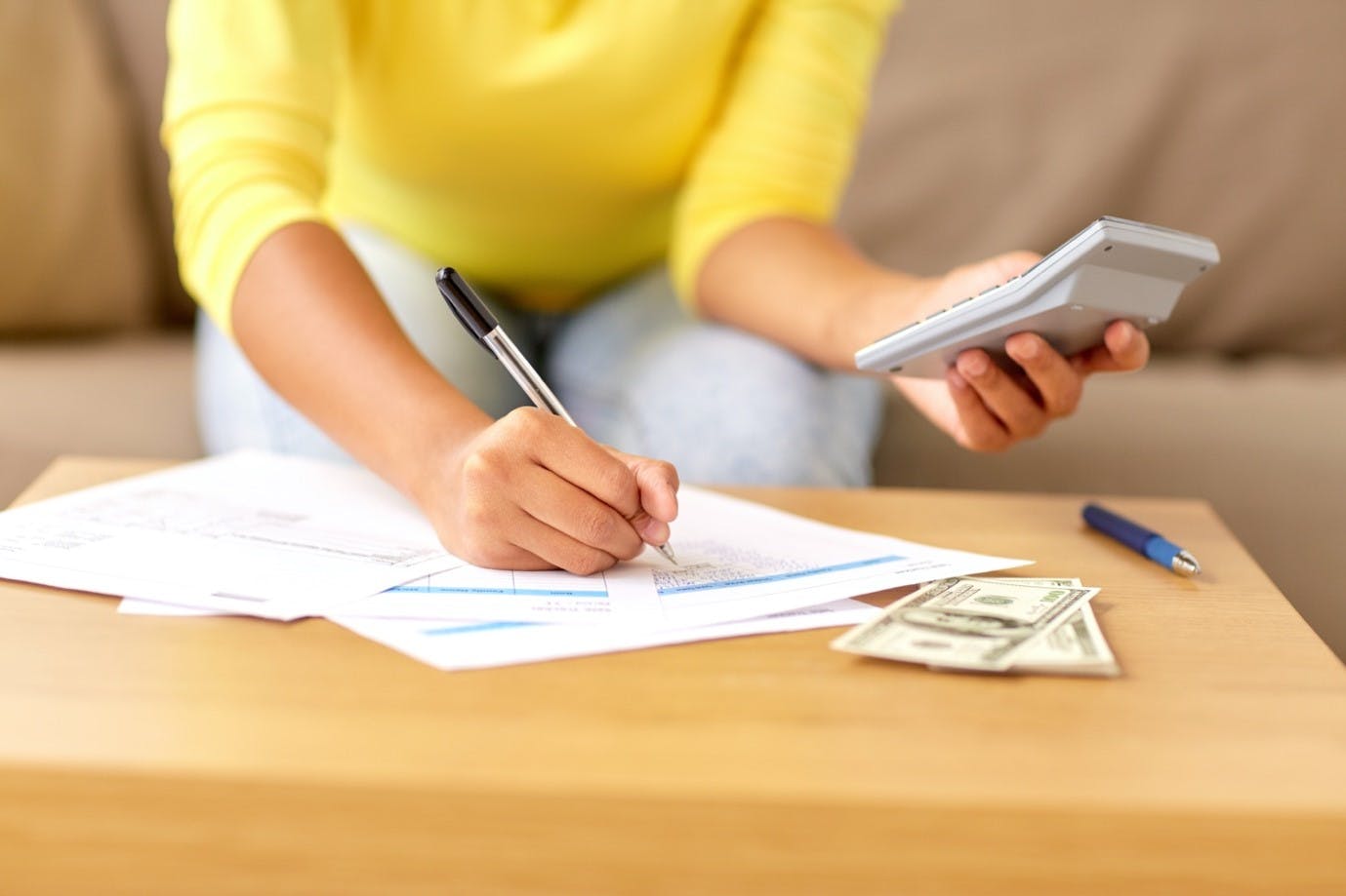 Woman holding calculator and planning a budget