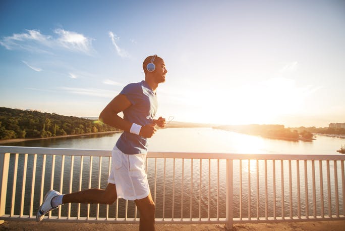 Male jogging across bridge