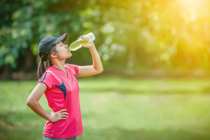 Woman in sports clothes drinking an electrolyte drink Woman in sports clothes drinking an electrolyte drink