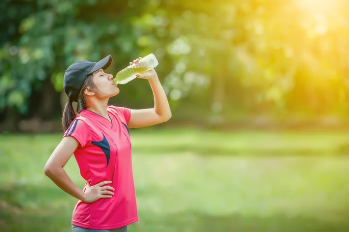 Woman in sports clothes drinking an electrolyte drink