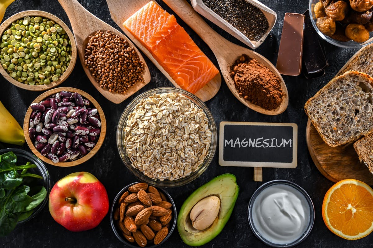 A small chalkboard that reads Magnesium is surrounded by foods that naturally contain magnesium like lentils and salmon A small chalkboard that reads Magnesium is surrounded by foods that naturally contain magnesium like lentils and salmon