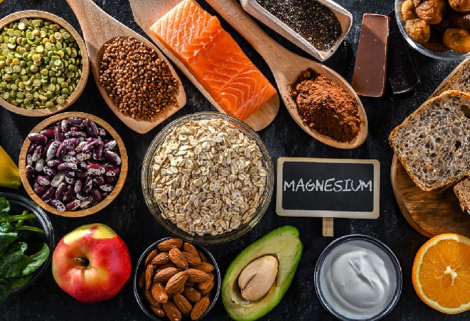 Woman holding two orange slices against her eyes.