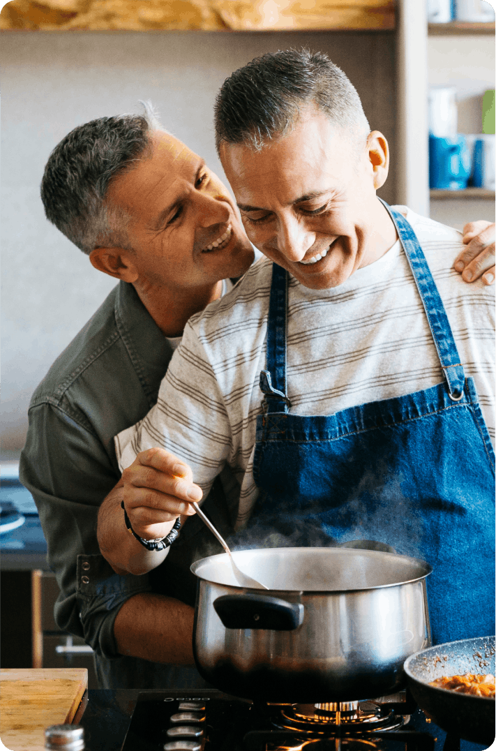 Two men are cooking and smilling