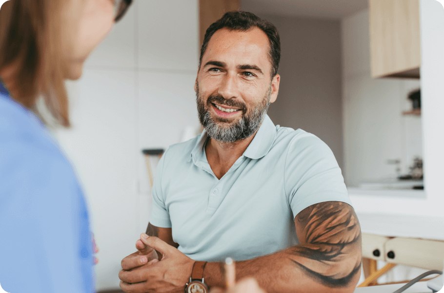 Smiling bearded man with tattoos talking to a woman in a modern kitchen