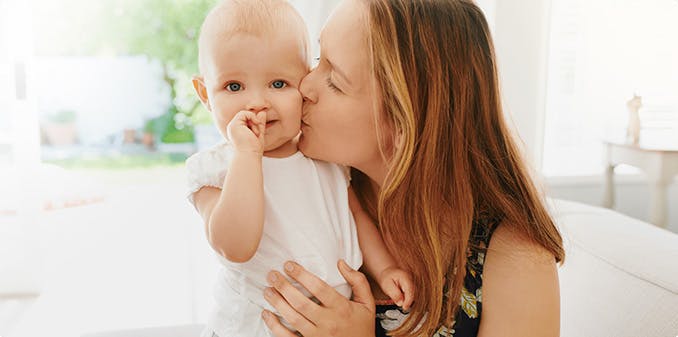 Mother kissing child's cheek