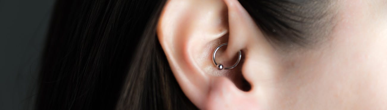 A woman has an earring to relieve migraines.