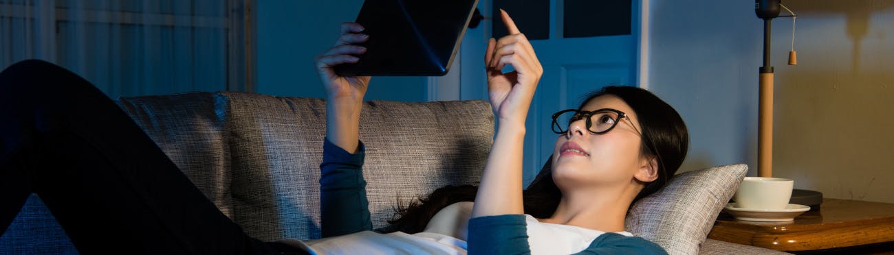 Woman lounging on couch with tablet