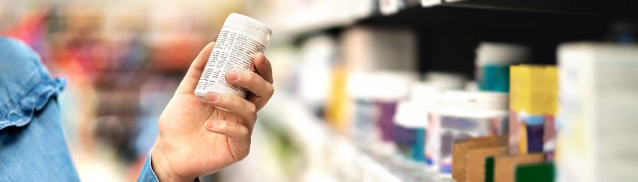 woman in a green shirt shopping at a pharmacy