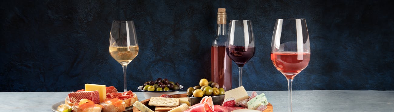 wine and charcuterie board with aged cheeses, salami, and olives