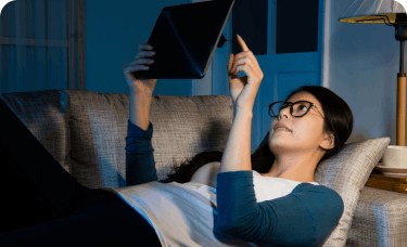 Woman lounging on couch with tablet