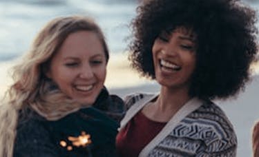 Two women laughing on a beach