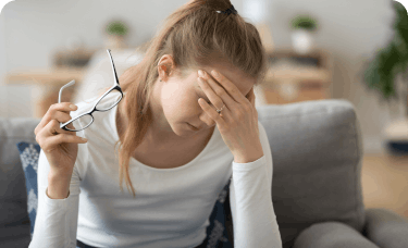 Woman with glasses wondering if she has a headache or a migraine