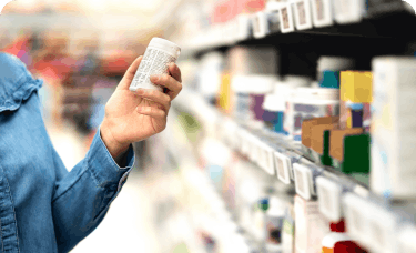 woman in a green shirt shopping at a pharmacy